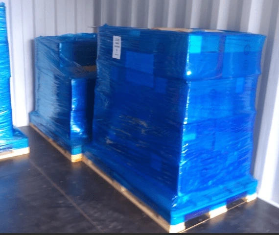 Blue shrink wrapped pallets in a shipping container for shipping from Japan to the UK