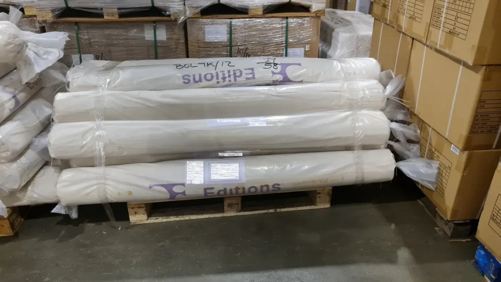 Rolls of rugs on a pallet for shipping from India to the UK